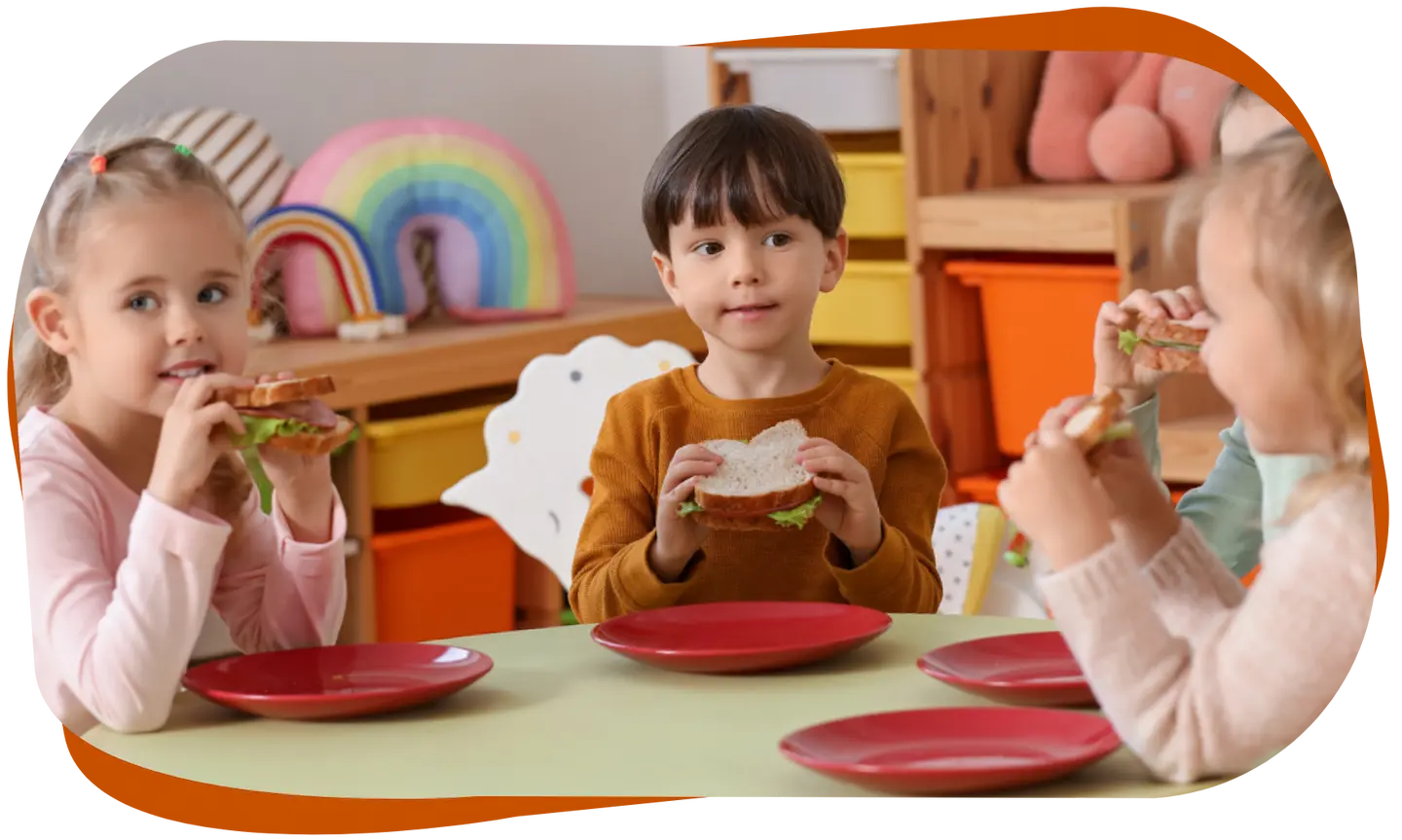 Kinder essen gemeinsam belegte Brote am Tisch
