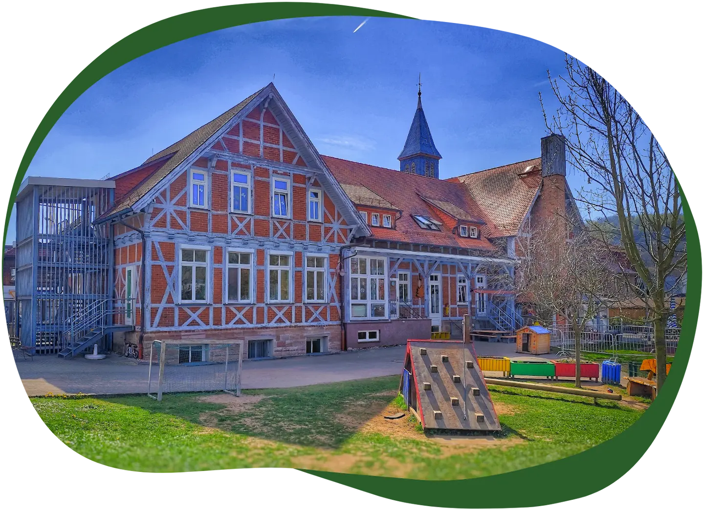 Außenansicht des Kindergarten Sonnenschein mit Fachwerkgebäude und Spielplatz